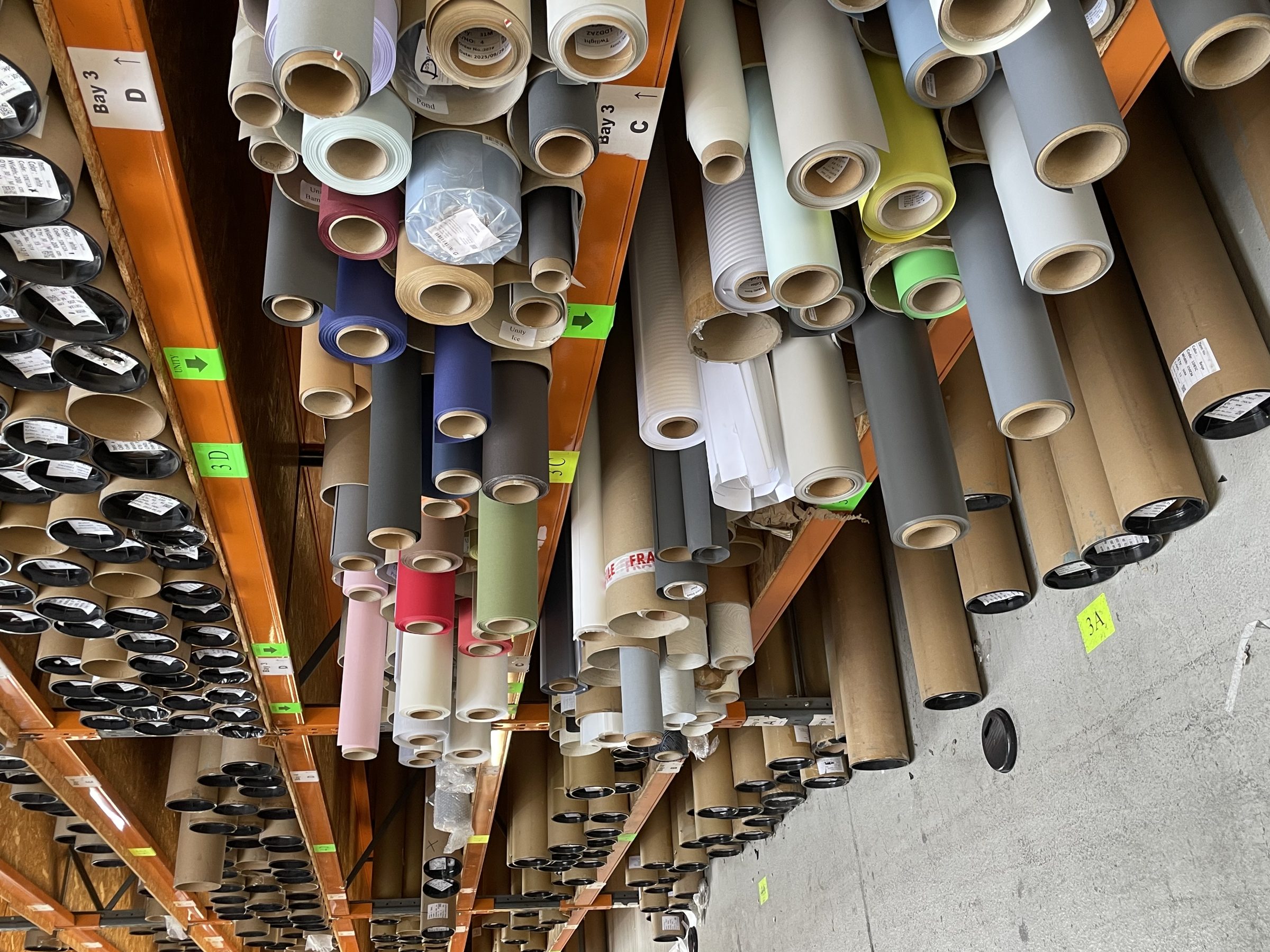Industrial racking stacked with rolls of stock in a warehouse